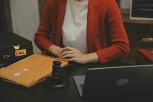 Business and lawyers discussing contract papers with brass scale on desk in office. Law, legal services, advice, justice and law concept picture with film grain effect photo