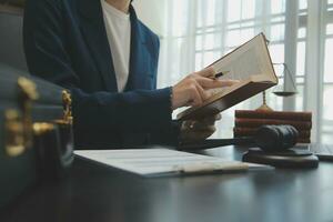 Business and lawyers discussing contract papers with brass scale on desk in office. Law, legal services, advice, justice and law concept picture with film grain effect photo