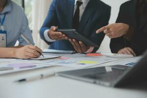 Financial analysts analyze business financial reports on a digital tablet planning investment project during a discussion at a meeting of corporate showing the results of their successful teamwork. photo