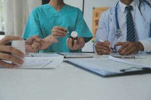 Doctor sitting at desk and writing a prescription for her patient photo