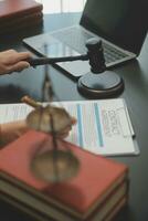 Business and lawyers discussing contract papers with brass scale on desk in office. Law, legal services, advice, justice and law concept picture with film grain effect photo