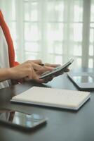 Close up Business woman using calculator and laptop for do math finance on wooden desk, tax, accounting, statistics and analytical research concept photo