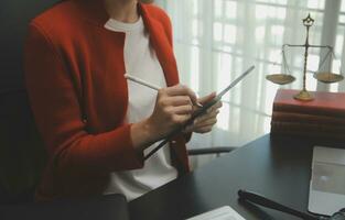 Business and lawyers discussing contract papers with brass scale on desk in office. Law, legal services, advice, justice and law concept picture with film grain effect photo