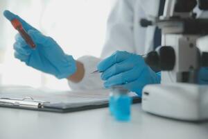Professional lab. Amazing longhaired medical worker wearing uniform while using microscope during research photo