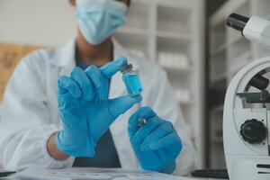Professional lab. Amazing longhaired medical worker wearing uniform while using microscope during research photo