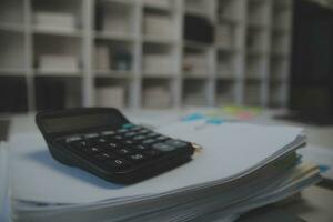 Business accounting concept, Business Man using calculator with computer laptop,pen, budget and loan paper in office. photo