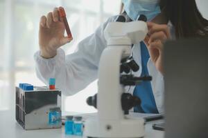Professional lab. Amazing longhaired medical worker wearing uniform while using microscope during research photo