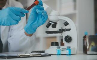 Professional lab. Amazing longhaired medical worker wearing uniform while using microscope during research photo