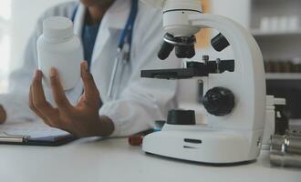 Professional lab. Amazing longhaired medical worker wearing uniform while using microscope during research photo