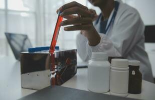 Professional lab. Amazing longhaired medical worker wearing uniform while using microscope during research photo