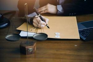 Justice and law concept.Male judge in a courtroom with the gavel, working with, computer and docking keyboard, eyeglasses, on table in morning light photo