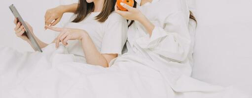 happy teenage girls friend using mobile phone for online shopping in bedroom photo