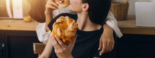 Laughing group of diverse young woman hanging out at home together and eating pizza photo