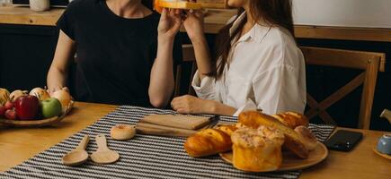 Laughing group of diverse young woman hanging out at home together and eating pizza photo