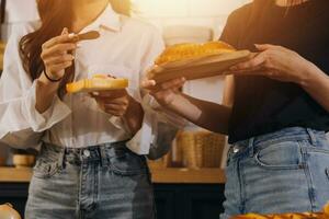 Laughing group of diverse young woman hanging out at home together and eating pizza photo