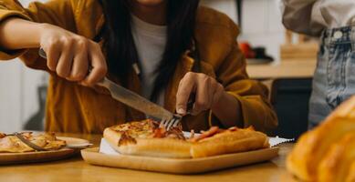 Laughing group of diverse young woman hanging out at home together and eating pizza photo