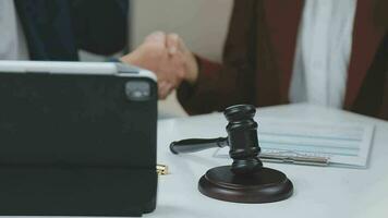 Justice and law concept.Male judge in a courtroom with the gavel, working with, computer and docking keyboard, eyeglasses, on table in morning light video