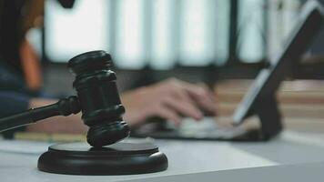 Justice and law concept.Male judge in a courtroom with the gavel, working with, computer and docking keyboard, eyeglasses, on table in morning light video