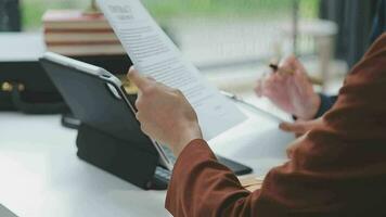 concetto di giustizia e diritto. giudice maschio in un'aula di tribunale con il martelletto, lavorando con computer e tastiera docking, occhiali, sul tavolo alla luce del mattino video