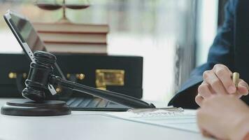 Justice and law concept.Male judge in a courtroom with the gavel, working with, computer and docking keyboard, eyeglasses, on table in morning light video