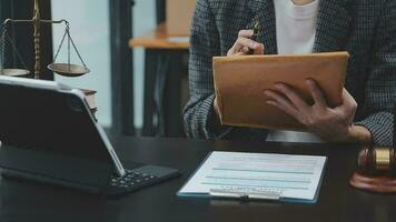 concetto di giustizia e diritto. giudice maschio in un'aula di tribunale con il martelletto, lavorando con computer e tastiera docking, occhiali, sul tavolo alla luce del mattino video