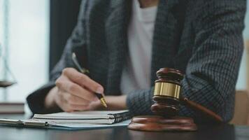 Justice and law concept.Male judge in a courtroom with the gavel, working with, computer and docking keyboard, eyeglasses, on table in morning light video