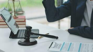 Justice and law concept.Male judge in a courtroom with the gavel, working with, computer and docking keyboard, eyeglasses, on table in morning light video