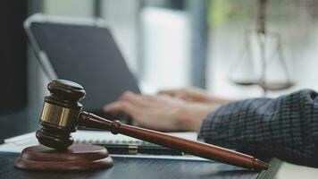 Justice and law concept.Male judge in a courtroom with the gavel, working with, computer and docking keyboard, eyeglasses, on table in morning light video