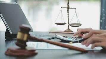 Justice and law concept.Male judge in a courtroom with the gavel, working with, computer and docking keyboard, eyeglasses, on table in morning light video