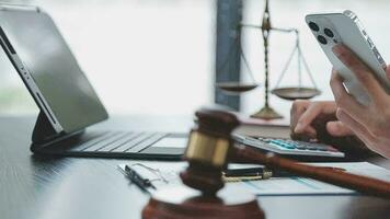 Justice and law concept.Male judge in a courtroom with the gavel, working with, computer and docking keyboard, eyeglasses, on table in morning light video