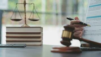 Justice and law concept.Male judge in a courtroom with the gavel, working with, computer and docking keyboard, eyeglasses, on table in morning light video