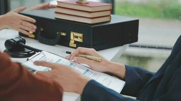 concetto di giustizia e diritto. giudice maschio in un'aula di tribunale con il martelletto, lavorando con computer e tastiera docking, occhiali, sul tavolo alla luce del mattino video