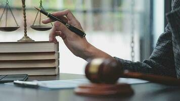 Justice and law concept.Male judge in a courtroom with the gavel, working with, computer and docking keyboard, eyeglasses, on table in morning light video