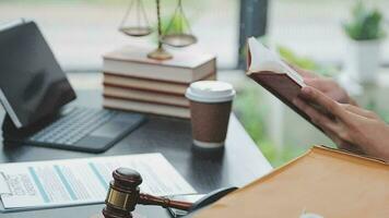 Justice and law concept.Male judge in a courtroom with the gavel, working with, computer and docking keyboard, eyeglasses, on table in morning light video