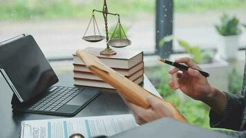 Justice and law concept.Male judge in a courtroom with the gavel, working with, computer and docking keyboard, eyeglasses, on table in morning light video