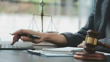 Justice and law concept.Male judge in a courtroom with the gavel, working with, computer and docking keyboard, eyeglasses, on table in morning light video