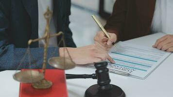 concetto di giustizia e diritto. giudice maschio in un'aula di tribunale con il martelletto, lavorando con computer e tastiera docking, occhiali, sul tavolo alla luce del mattino video