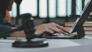 Justice and law concept.Male judge in a courtroom with the gavel, working with, computer and docking keyboard, eyeglasses, on table in morning light video