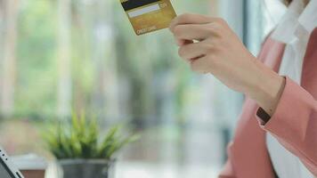 fechar a mão da mulher usando cartão de crédito e laptop smartphone para fazer compras online video