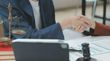 concetto di giustizia e diritto. giudice maschio in un'aula di tribunale con il martelletto, lavorando con computer e tastiera docking, occhiali, sul tavolo alla luce del mattino video