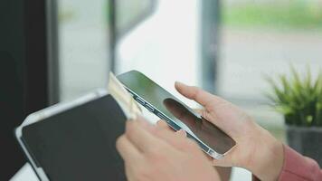 Close up woman hand using credit card and smartphone laptop for buying online shopping video