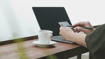 in linea pagamento, giovane donna Tenere credito carta e digitando su il computer portatile video