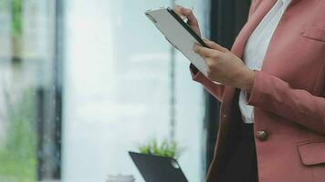 Financial analysts analyze business financial reports on a digital tablet planning investment project during a discussion at a meeting of corporate showing the results of their successful teamwork. video