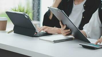 Financial analysts analyze business financial reports on a digital tablet planning investment project during a discussion at a meeting of corporate showing the results of their successful teamwork. video