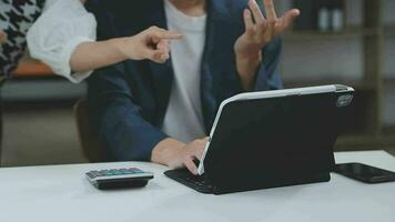 Financial analysts analyze business financial reports on a digital tablet planning investment project during a discussion at a meeting of corporate showing the results of their successful teamwork. video