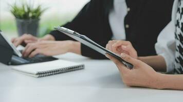 Financial analysts analyze business financial reports on a digital tablet planning investment project during a discussion at a meeting of corporate showing the results of their successful teamwork. video