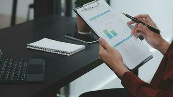 Financial analysts analyze business financial reports on a digital tablet planning investment project during a discussion at a meeting of corporate showing the results of their successful teamwork. video