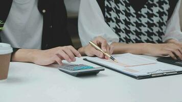 financiële analisten analyseren zakelijke financiële rapporten over een investeringsproject voor digitale tabletplanning tijdens een discussie op een bijeenkomst van bedrijven die de resultaten van hun succesvolle teamwerk laten zien. video