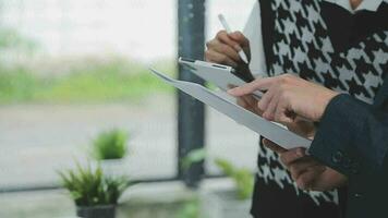 Financial analysts analyze business financial reports on a digital tablet planning investment project during a discussion at a meeting of corporate showing the results of their successful teamwork. video