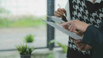 Financial analysts analyze business financial reports on a digital tablet planning investment project during a discussion at a meeting of corporate showing the results of their successful teamwork. video